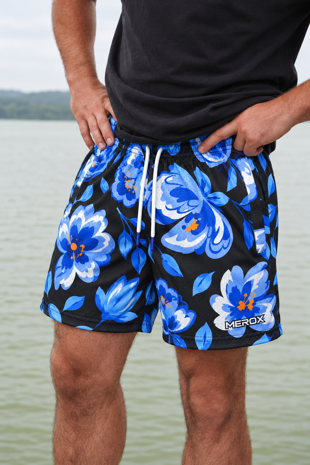 Real adult male model photo digitally adapted to MEROX Blue Floral shorts with small logo; AI-assisted garment visualization