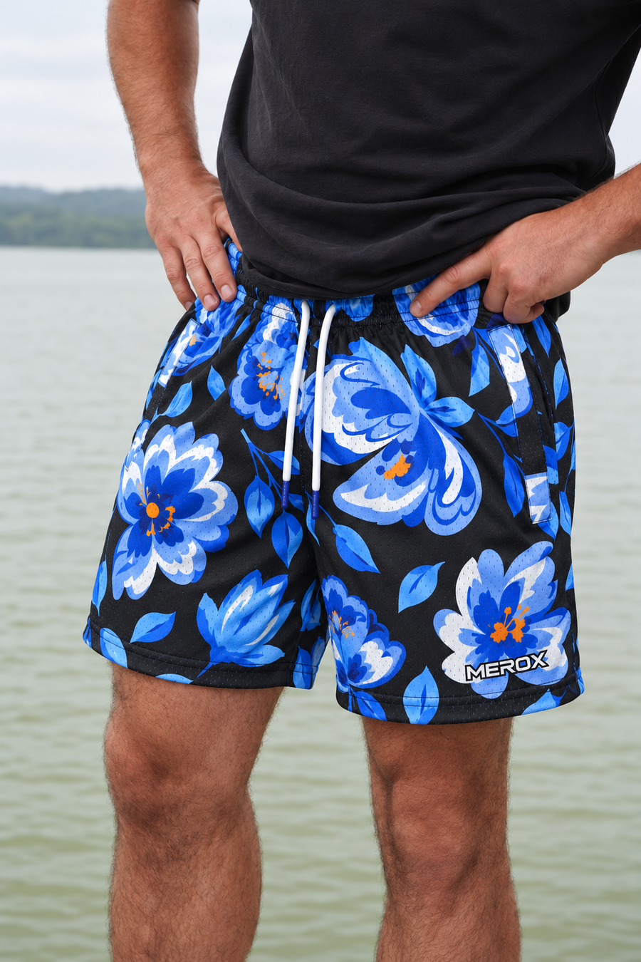 Real adult male model photo digitally adapted to MEROX Blue Floral shorts with small logo; AI-assisted garment visualization