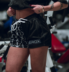 Woman wearing MEROX Half Black Barbed Wire mesh shorts; approved existing-photo logo correction