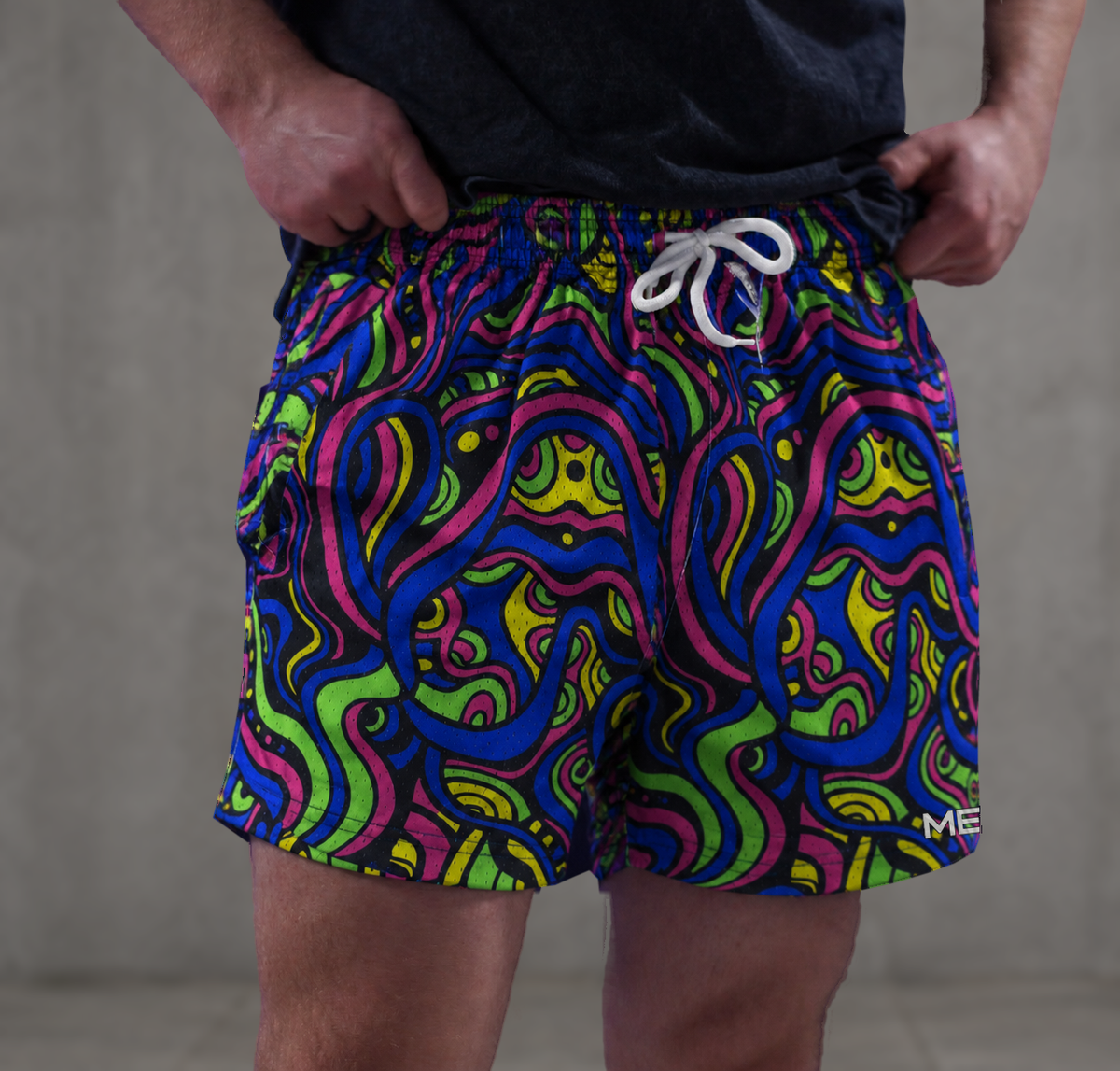 Man wearing MEROX Psychedelic mesh shorts against a concrete background; approved owned-photo garment adaptation with naturally wrapped logo