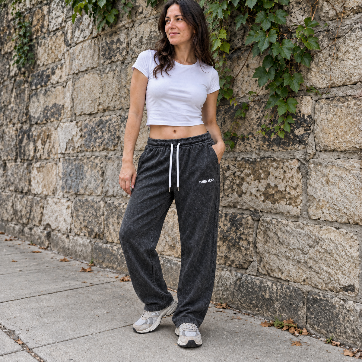 Female model wearing MEROX black acid wash straight-leg joggers outdoors