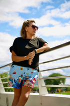 Real adult female model wearing Ocean mesh shorts; localized legacy logo cleanup