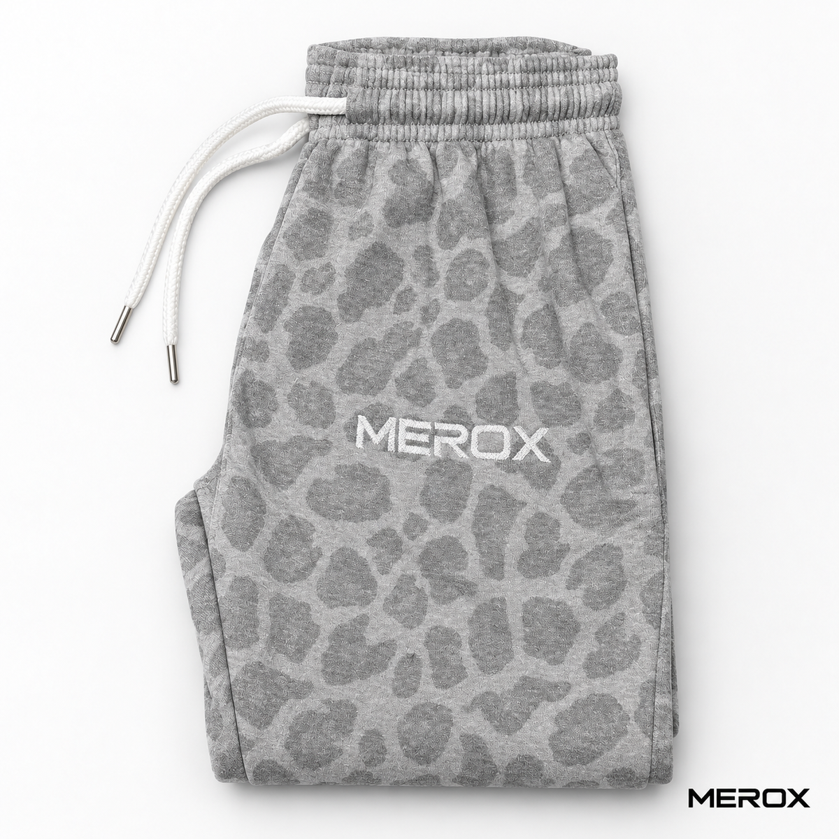 Folded MEROX cheetah joggers showing pattern, drawstrings and embroidered logo