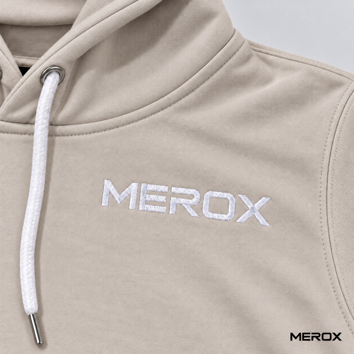 White embroidered MEROX logo detail on khaki hoodie