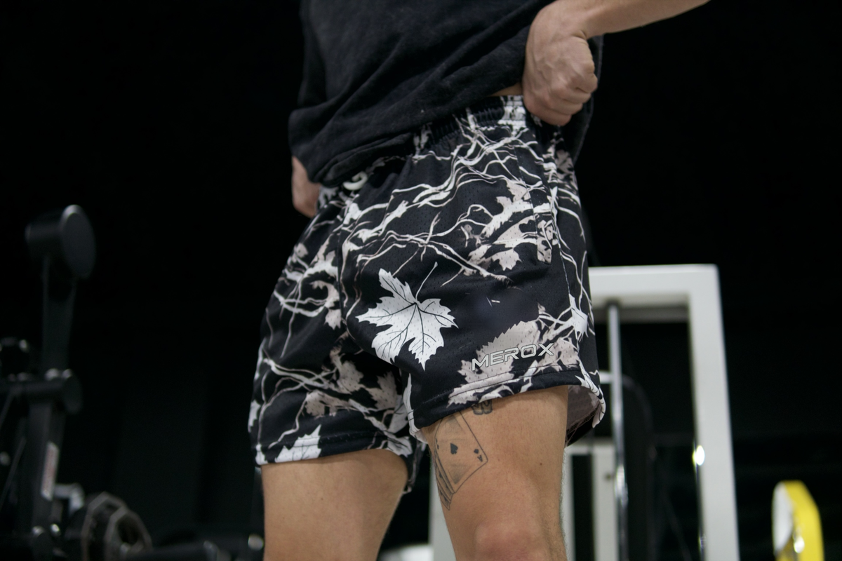 Model wearing MEROX Black and White Maple Camo 5-inch mesh shorts