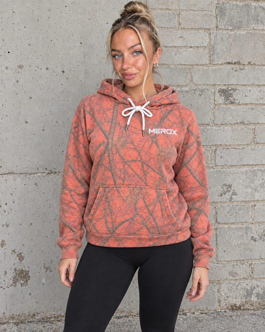 Woman wearing MEROX Orange Camo embroidered hoodie