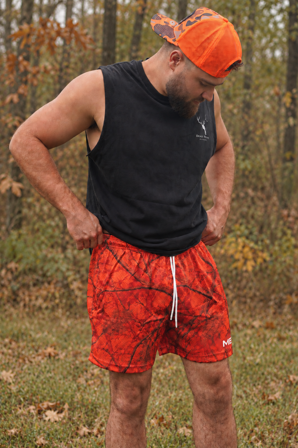 Approved male model wearing MEROX Orange Camo mesh shorts