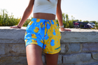 Approved female C wearing MEROX Rubber Duck mesh shorts with corrected lower-right MER logo wrap