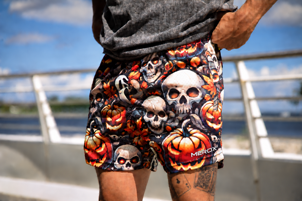 Man wearing MEROX Skull and Jack-o-Lantern 5-inch mesh shorts