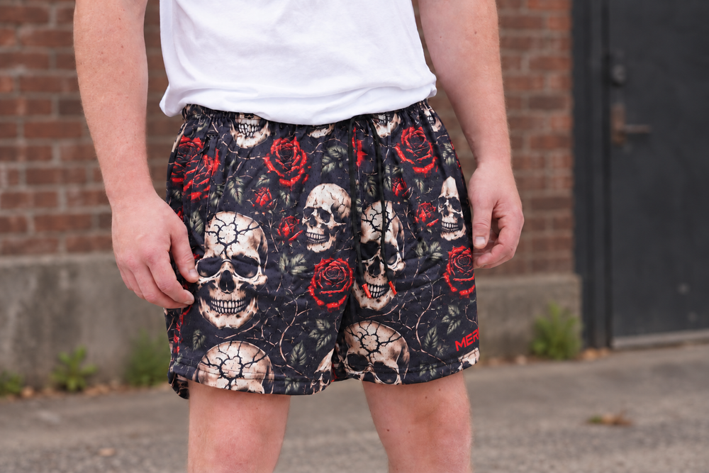 Man wearing MEROX Skull and Roses 5-inch mesh shorts, approved frontal view with smaller partial logo