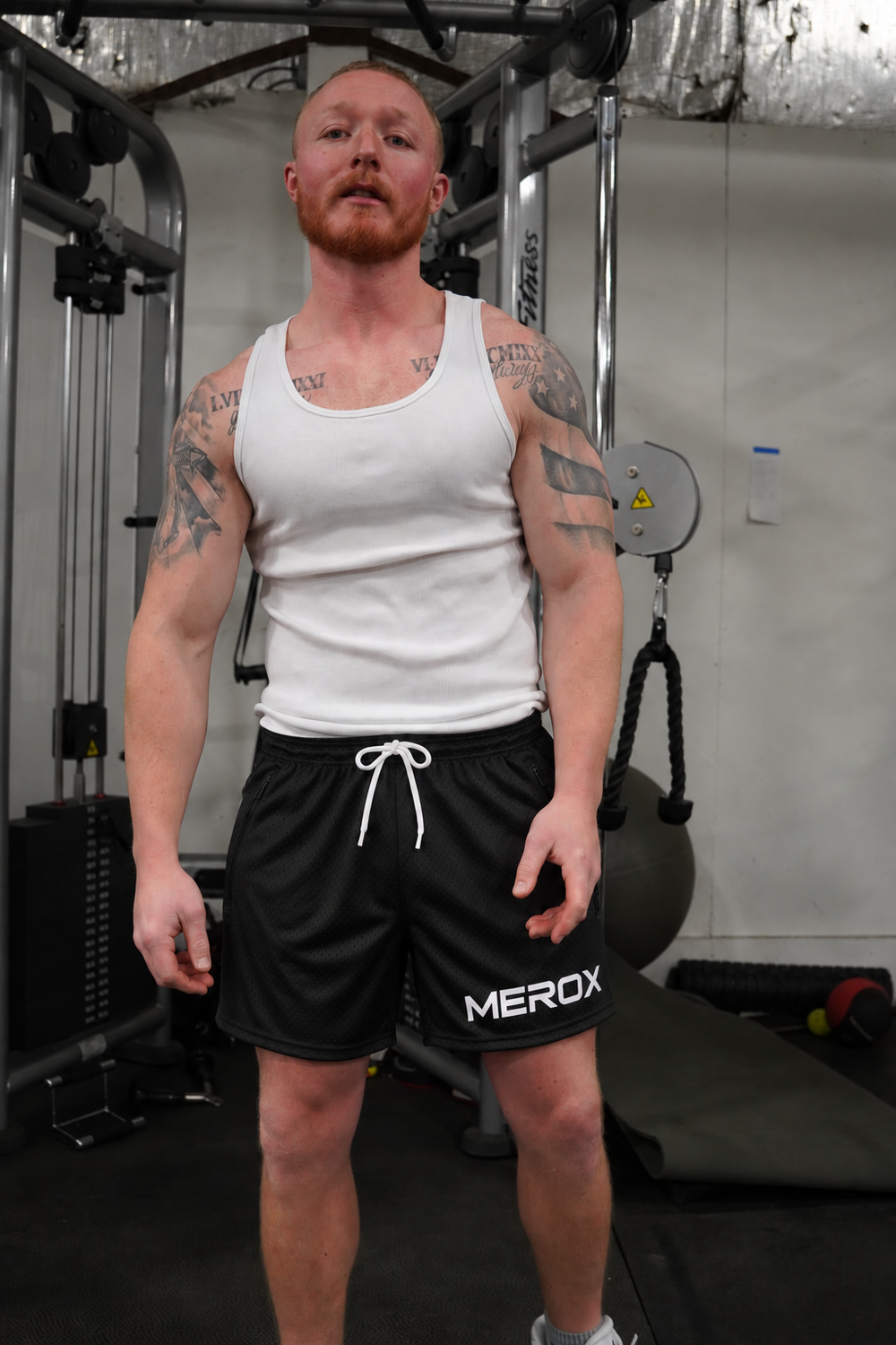 Man wearing MEROX Solid Black mesh shorts, approved large centered logo