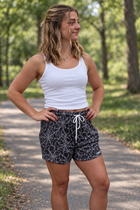 Female model wearing MEROX black-and-white Spider Web mesh shorts