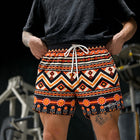 Male model wearing MEROX Tribal mesh shorts with orange and black Aztec print